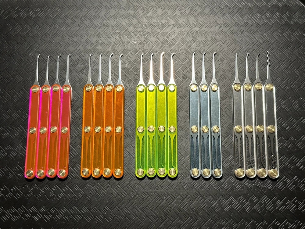 Set of colorful tools with metallic ends on a textured black background