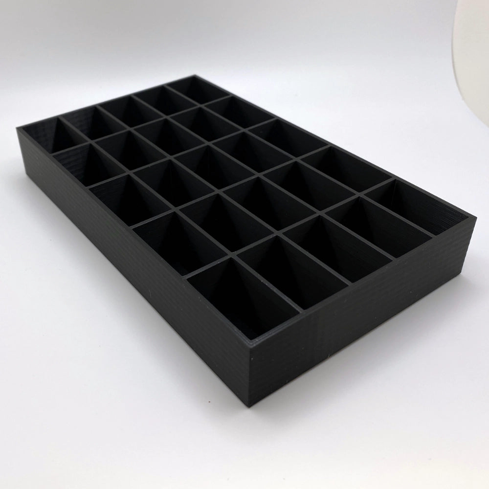 Black display tray with multiple compartments on a white background