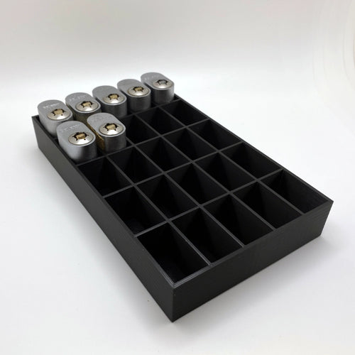 Black tray with compartments holding locks on a white background