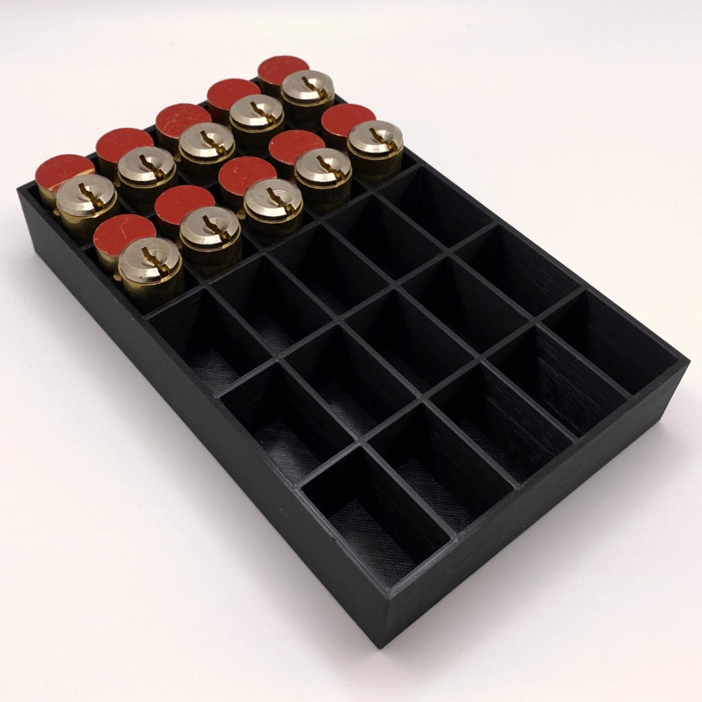 Black tray with compartments holding locks on a white background
