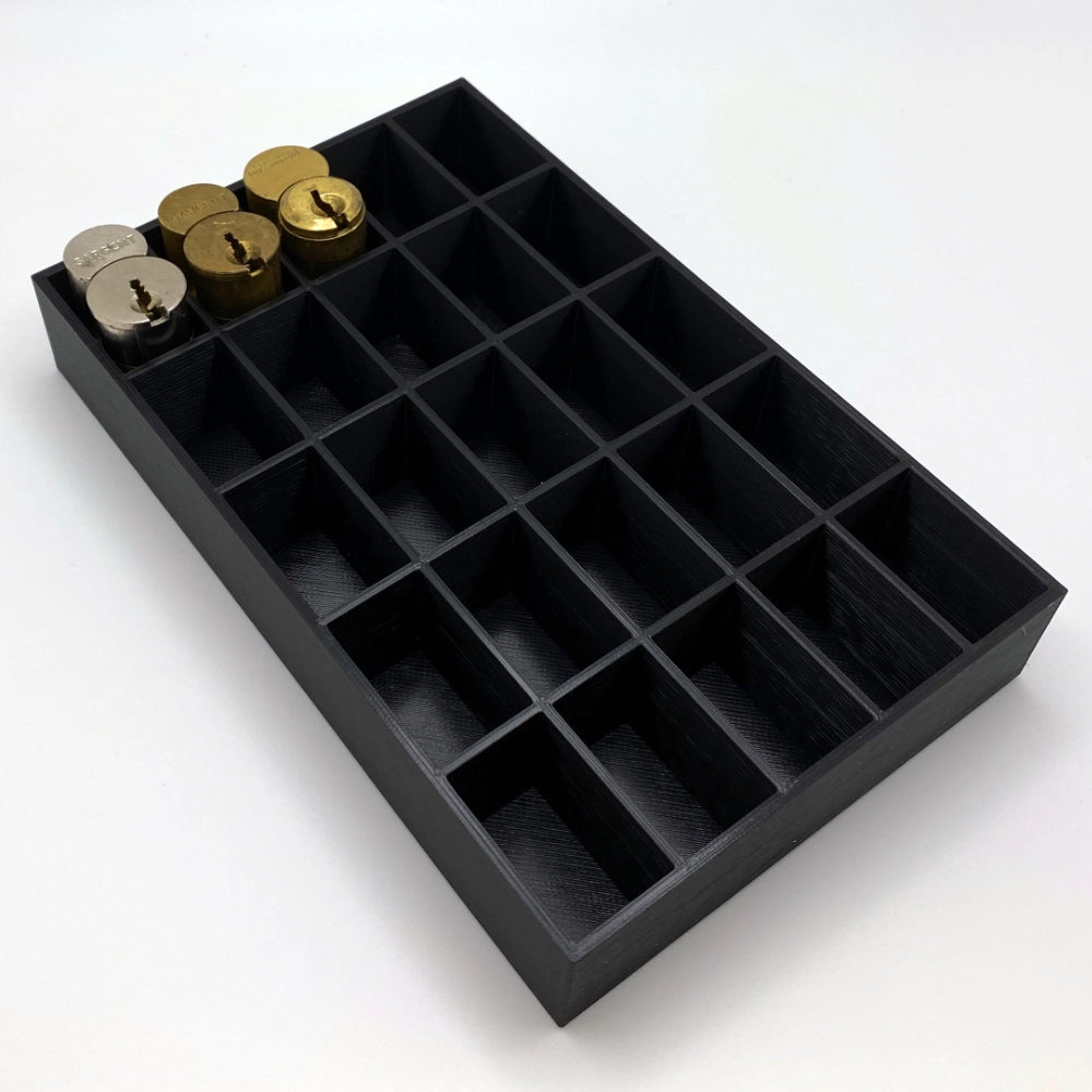 Black tray with compartments holding locks on a white background