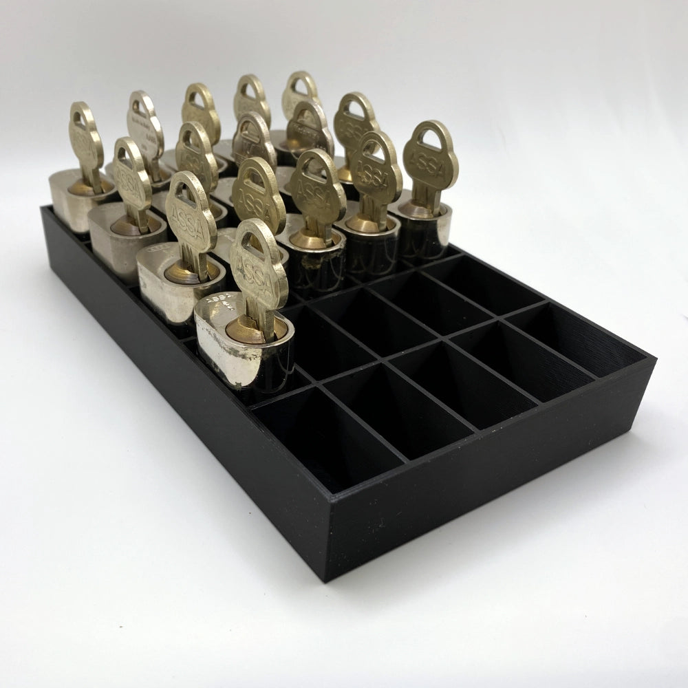 Black tray with compartments holding locks on a white background