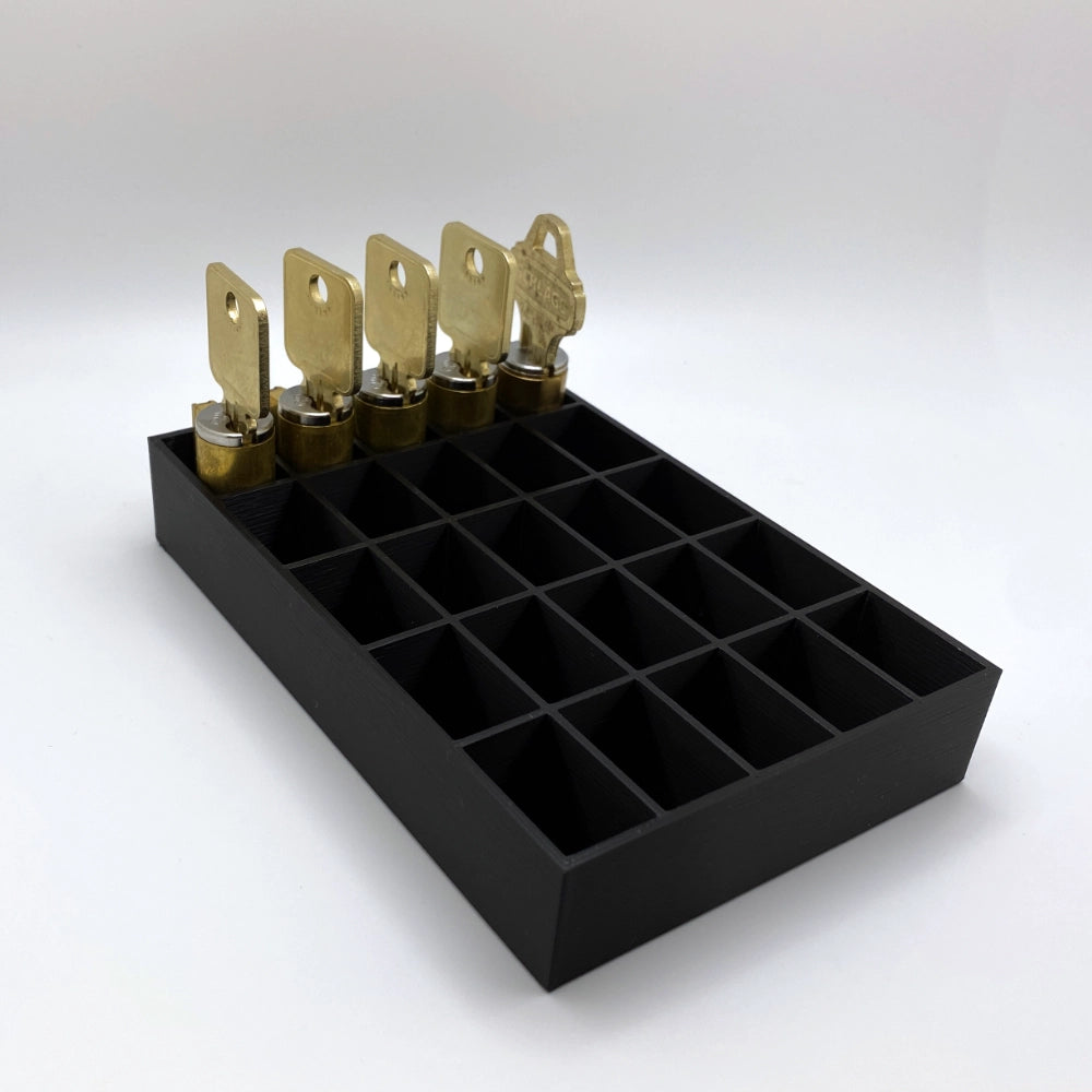 Black tray with compartments holding locks on a white background