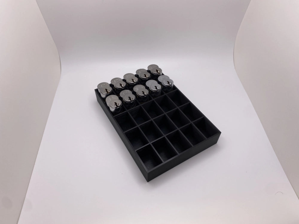 Black tray with compartments holding locks on a white background