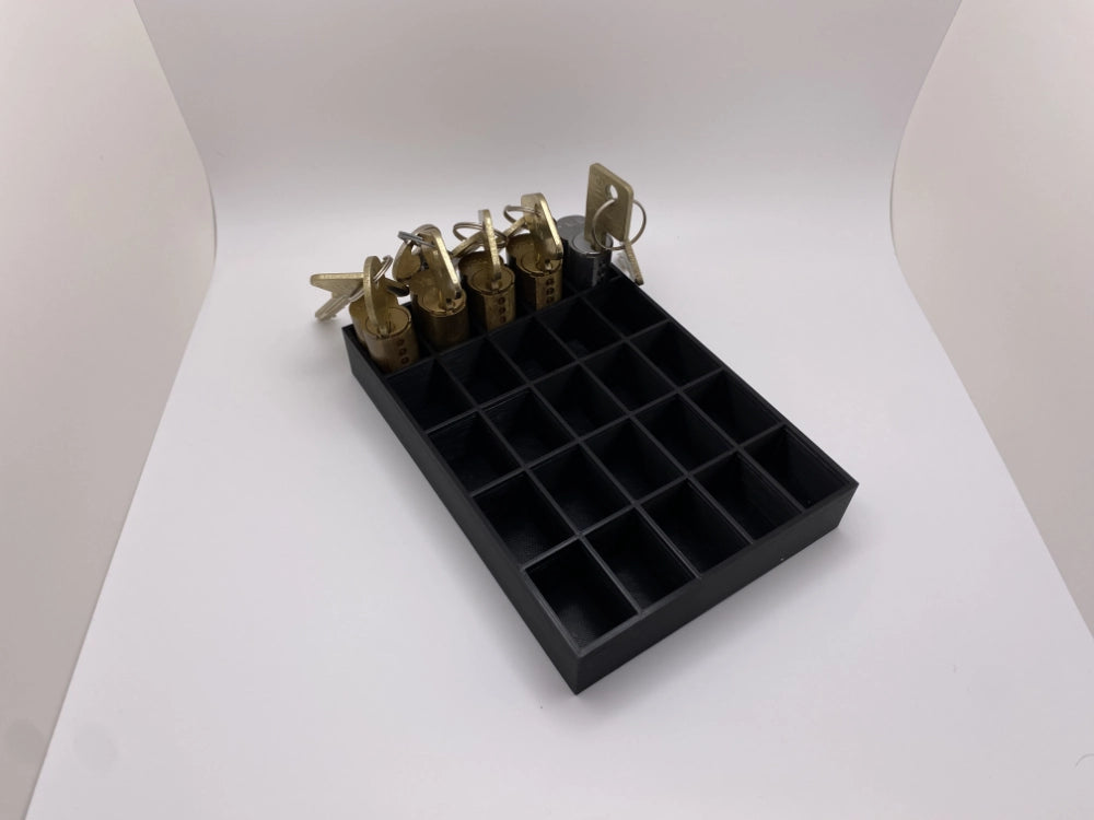 Black tray with compartments holding locks on a white background