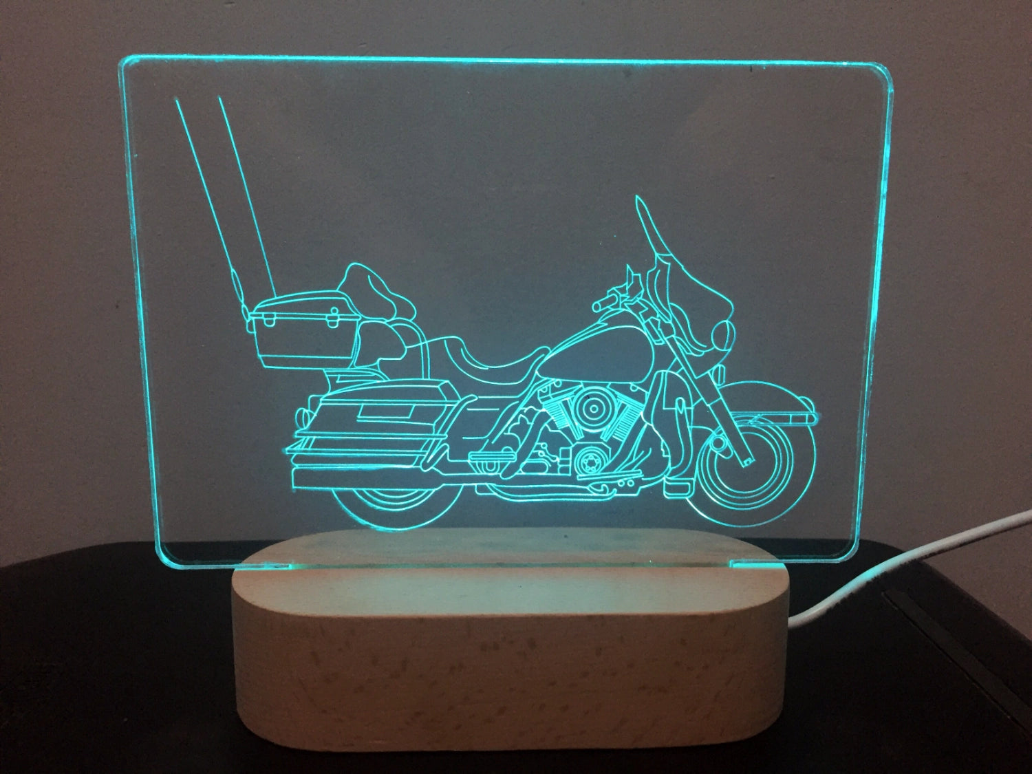 Motorcycle-themed LED lamp with wooden base on a dark surface
