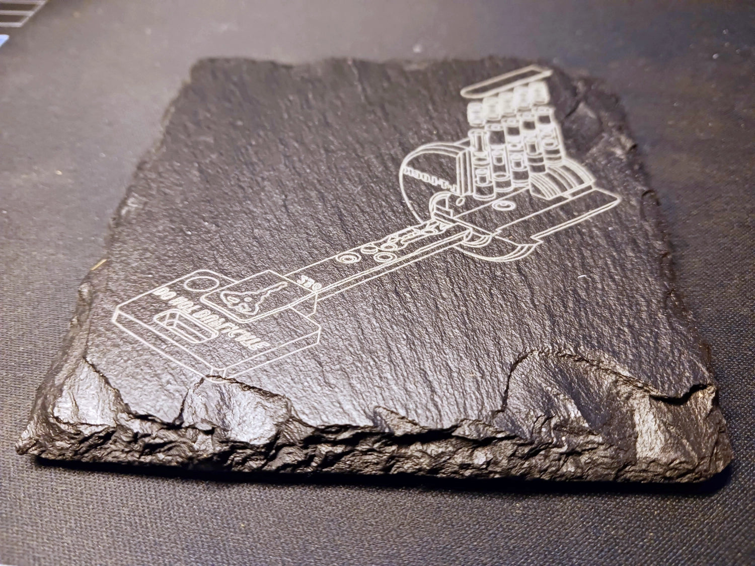Engraved design on a slate coaster