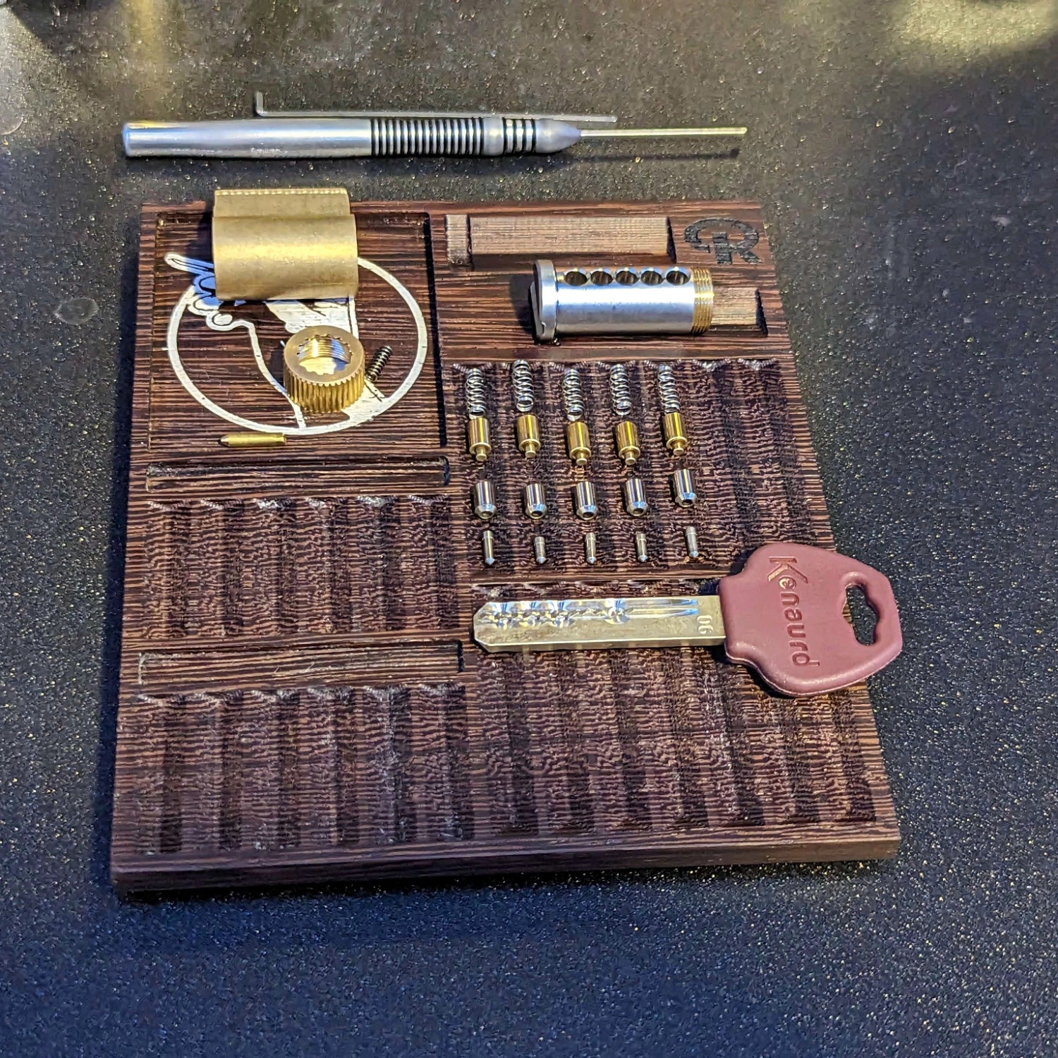 Wooden lock-picking tool set with various components on a dark surface