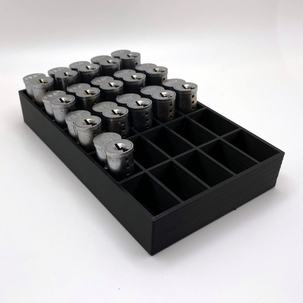 Black tray with compartments holding locks on a white background