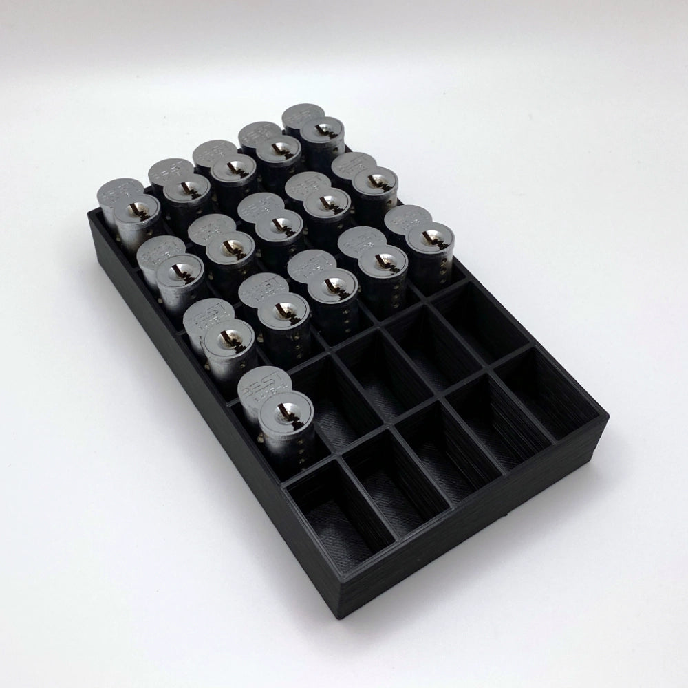 Black tray with compartments holding locks on a white background