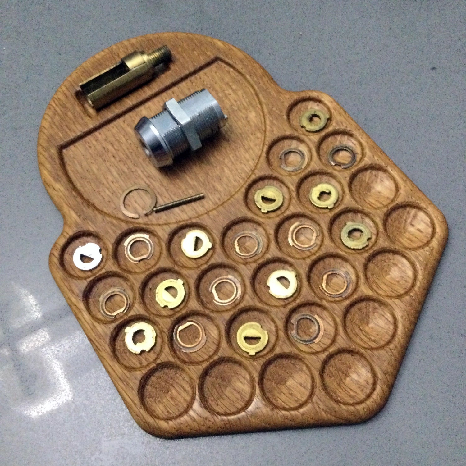 Wooden tool organizer with various small components on a gray background