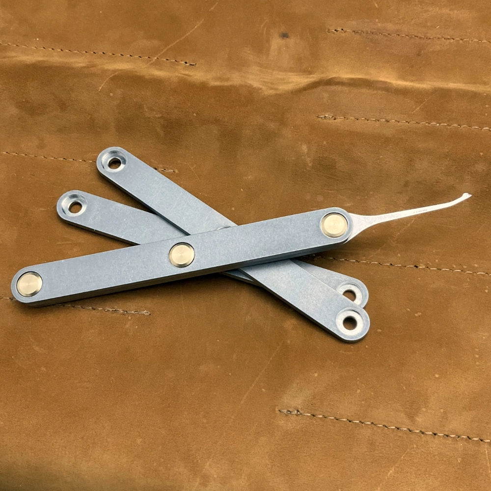 Metal lockpick on a brown leather surface