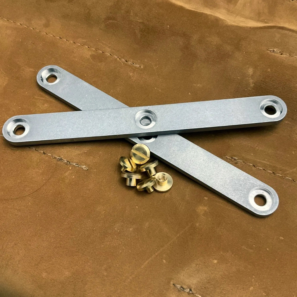 Metal handles with screws on a brown leather surface