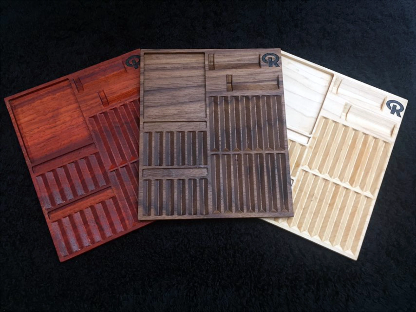 Three wooden trays with different patterns on a black background